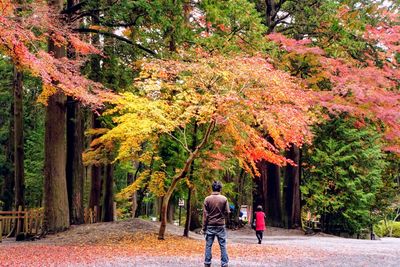 Rear view of women walking in park during autumn