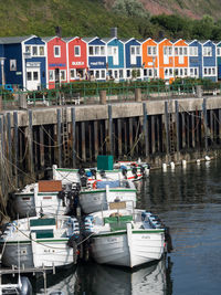 Fishing boats moored in river by buildings