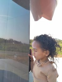 Portrait of girl looking through window