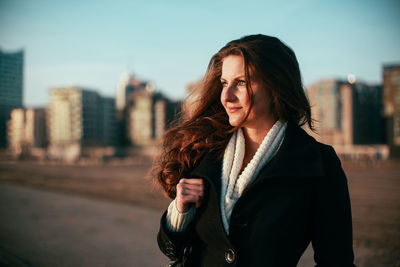 Portrait of woman looking at city against sky at hafencity hamburg