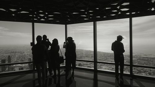 Silhouette people looking through window from burj khalifa