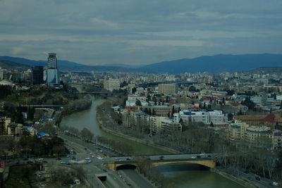 High angle view of river amidst buildings in city against sky