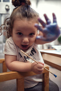 Children playing in an inner courtyard and painting with water paints