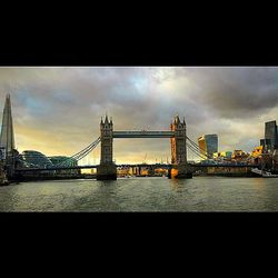 Bridge over river against cloudy sky