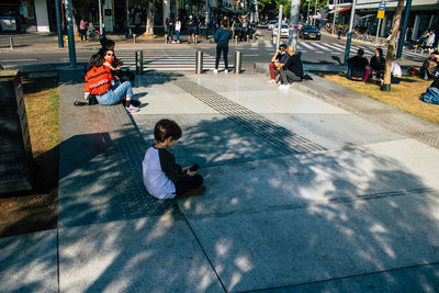 People sitting on footpath