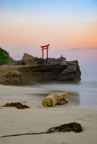 Scenic view of sea and shrine against sky during sunset