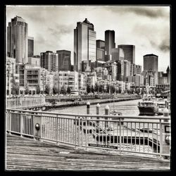 Buildings in city against cloudy sky