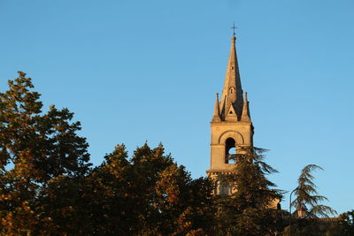 Low angle view of trees and building against sky