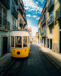 The famous yellow tram going through the streets of lisbon, portugal.