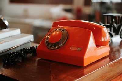 Close-up of red telephone on table