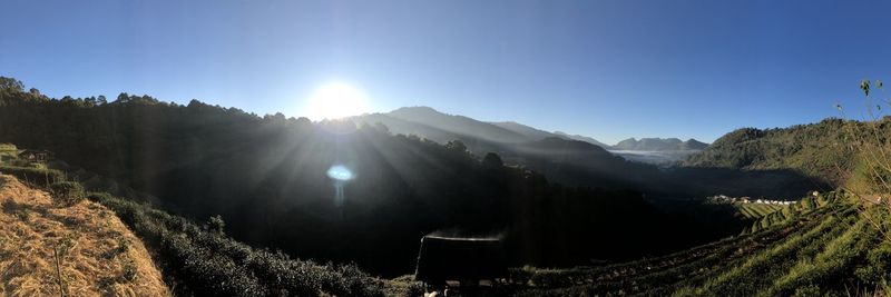 Panoramic view of mountains against bright sun