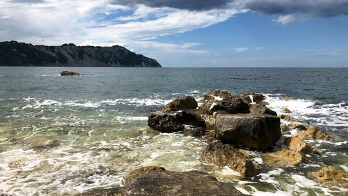 Rocks on sea shore against sky