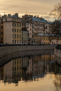 Buildings by lake against sky in city
