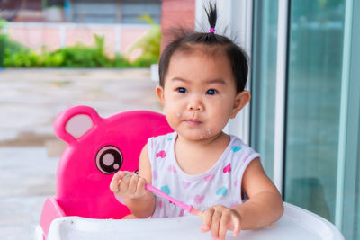 Cute baby girl sitting on high chair