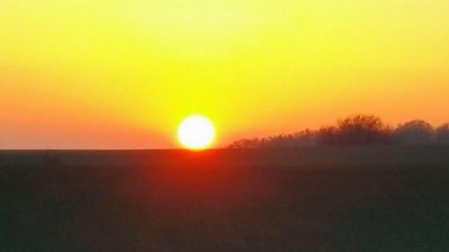 Silhouette landscape against clear sky during sunrise