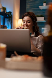 Young woman using laptop at table