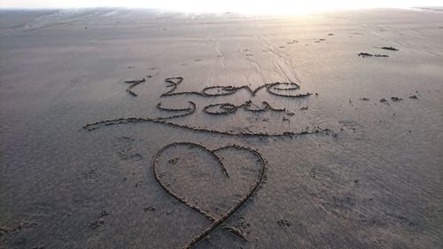 Close-up of text on sand at beach