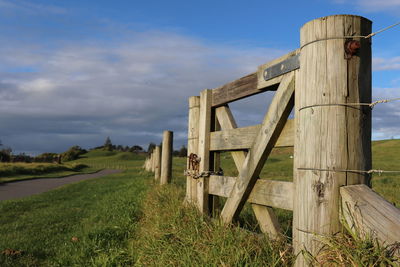 Wooden fence on field against sky