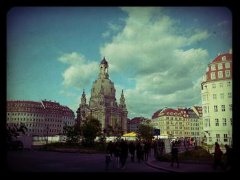 Buildings in city against cloudy sky