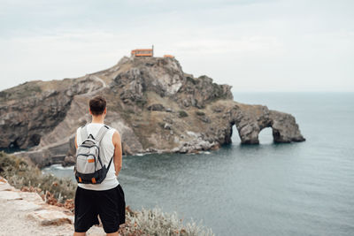 Rear view of man looking at sea against sky