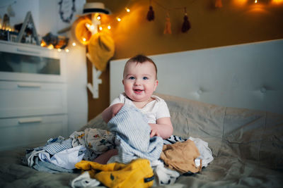 High angle view of cute girl sitting on bed at home