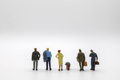 Rear view of people standing against white background