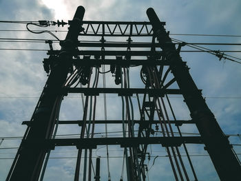 Low angle view of silhouette electricity pylon against sky