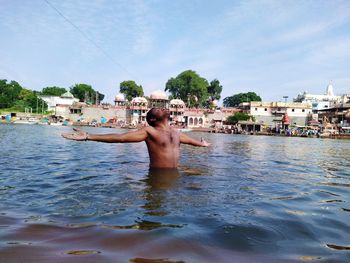 Man surfing in water against sky