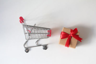 Close-up of miniature shopping cart against white background