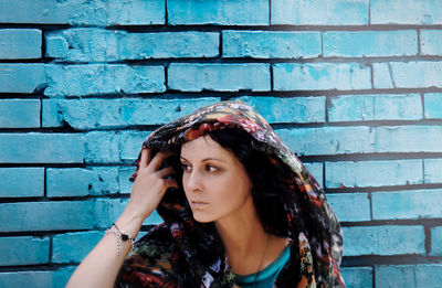 Portrait of a young woman against wall