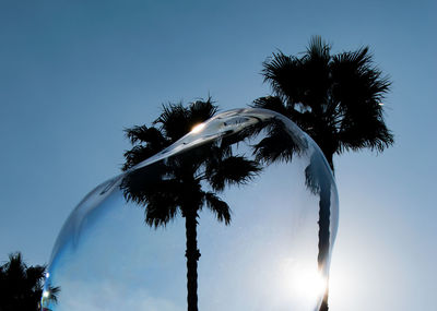 Low angle view of palm tree against clear blue sky