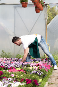 Rear view of man working on flowering plant