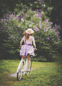 Woman riding bicycle on grass