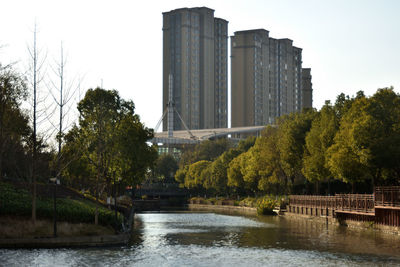 Scenic view of river by buildings against clear sky