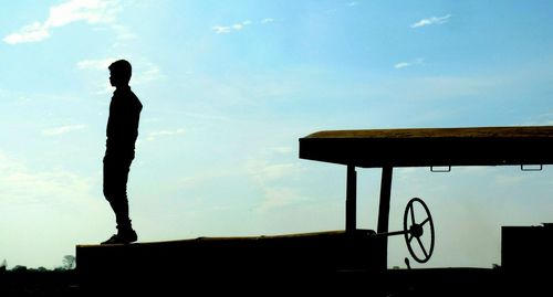 Low angle view of silhouette man standing against sky