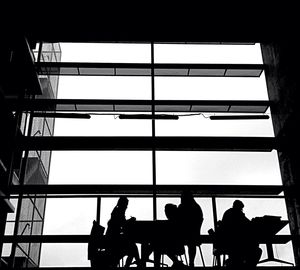 Low angle view of silhouette men against sky