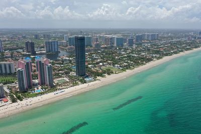 High angle view of city by sea against sky