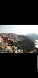 Aerial view of townscape and mountains against clear sky