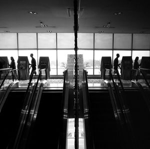 Two people walking beside escalators