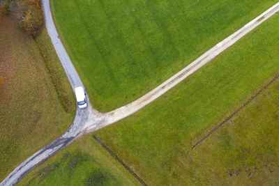 Drone view of van passing countryside crossroad in autumn