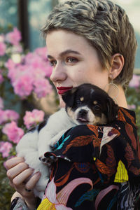 Close up blonde woman holding puppy in garden portrait picture