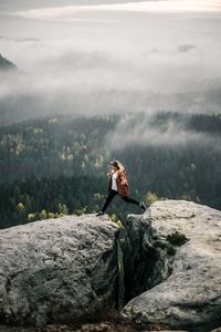 Man sitting on rock in mountains
