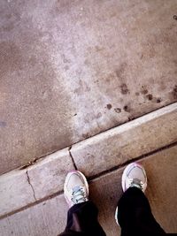 Low section of person standing on tiled floor