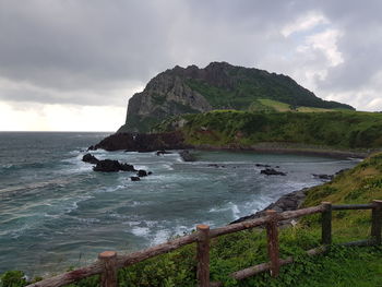 Scenic view of sea and mountains against sky