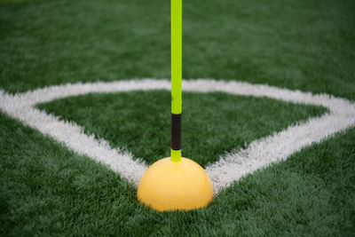 Close-up of yellow ball and corner marking on grassland