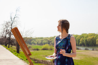 Woman looking at camera against sky