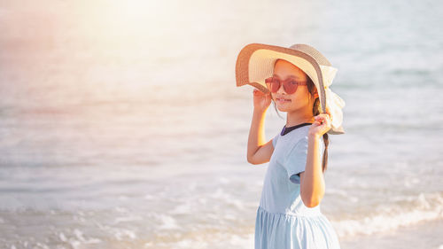 Woman wearing hat standing at beach