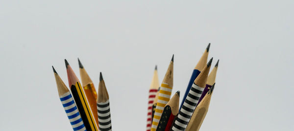 Close-up of multi colored pencils against white background