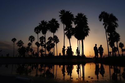 Silhouette of palm trees against sky during sunset