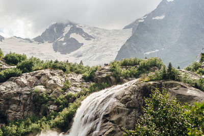 Scenic view of waterfall against sky